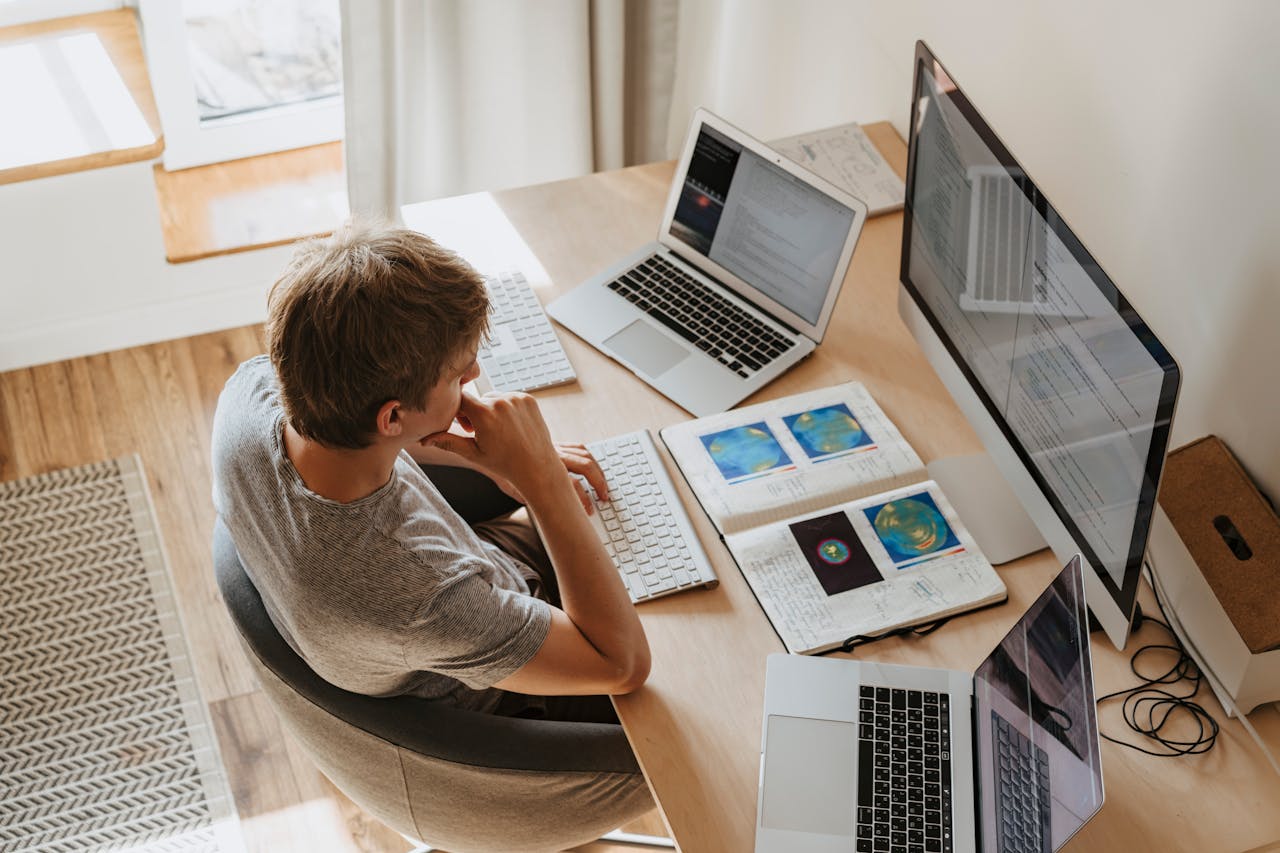 Boy sitting on chair while using his laptop